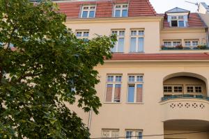un immeuble d'appartements avec un balcon et un arbre dans l'établissement Apartament Różana 21, à Poznań