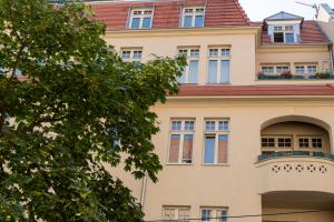 an apartment building with a balcony and a tree at Apartament Różana 21 in Poznań