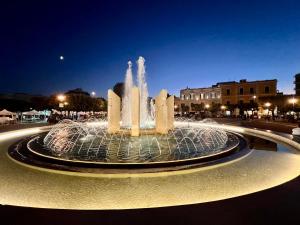 a water fountain in a city at night at Vittorio Emanuele Charming Suites in Monopoli