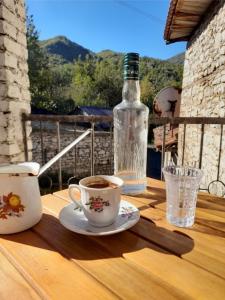 Bujtina Tusha في تيرانا: طاولة مع كوب من القهوة وزجاجة من الماء