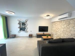 a living room with a couch and a flat screen tv at Villa Lifestyle & Trends in Limenaria