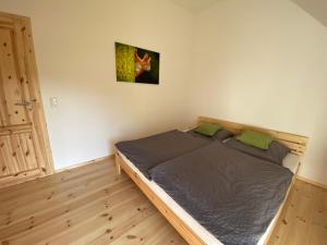 a bedroom with a bed with a wooden floor at Ferienhaus Halbritter Krina in Krina