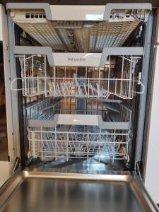 a dishwasher with its door open with dishes in it at Apartment mit Traumblick im Haus Olympia in Grächen