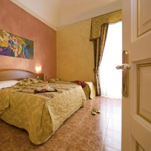 a hotel room with two beds and a window at Hotel Joli in Palermo