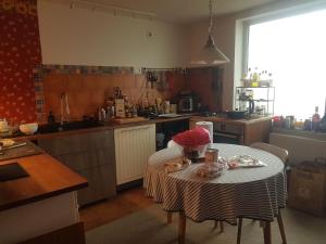 a kitchen with a table with a bowl of flowers on it at Story House 2 in Bragadiru