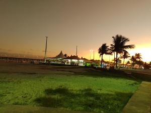 un parque con palmeras y una playa al atardecer en Casa de Praia com piscina, en Mongaguá