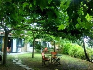 a table and chairs under a tree in a yard at Country Art Studio Alkyoni in Kokkino Nero +15 photos