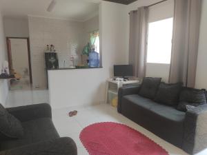 uma sala de estar com um sofá e uma mesa em Casa de Praia com piscina em Mongaguá
