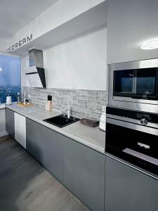 a kitchen with a sink and a microwave at sky DREAM jacuzzi sauna 33 FLOOR in Klaipėda
