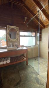 a bathroom with a glass shower and a sink at Zafiro Boutique Hotel in Mindo