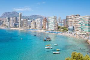 a beach with boats in the water next to a city at Paraiso Lido Sea Views 1-D Levante Beach in Benidorm