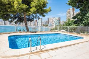 a swimming pool with a city skyline in the background at Paraiso Lido Sea Views 1-D Levante Beach in Benidorm