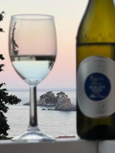 een glas wijn naast een fles wijn bij Seahaven in Petrovac na Moru