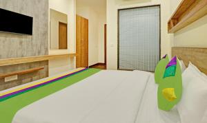 a bedroom with a white bed and a television at Treebo Trend Delmont in Chandīgarh