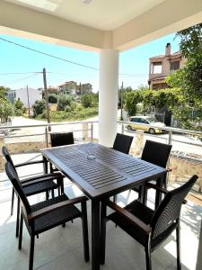einen Tisch und Stühle auf einer Veranda mit Straßenblick in der Unterkunft Villa Lifestyle & Trends in Kástron