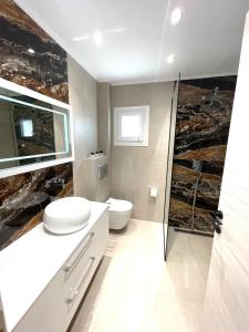 a bathroom with a toilet and a glass shower at Villa Lifestyle & Trends in Limenaria +33 photos