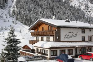 a large building in the snow in front of a mountain at Haus Elisabeth in Sankt Leonhard im Pitztal