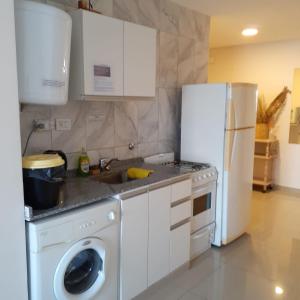 cocina con nevera blanca y lavadora en Departamento Alem 2 en exclusivo Barrio Martin en Rosario