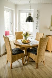 a dining room table and chairs with a bowl of fruit at Haus Sandglöckchen in Greetsiel