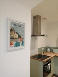 una cocina con una foto colgada en la pared en Appartement Zen au Cœur du Cotentin, en Valognes