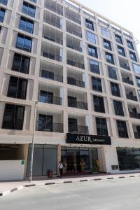 a large apartment building with a sign on it at Azur Regency Hotel Apartments in Dubai