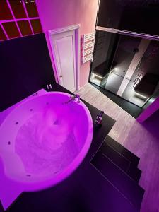 uma casa de banho roxa com uma grande banheira num quarto em sky DEEP jacuzzi 30 FLOOR em Klaipėda