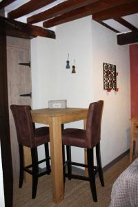 einen Holztisch und zwei Stühle in einem Zimmer in der Unterkunft Les Songes d'Héléna in Honfleur