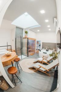 ein Wohnzimmer mit einem Tisch, Stühlen und einem Waschbecken in der Unterkunft NA Apartments in Maribor