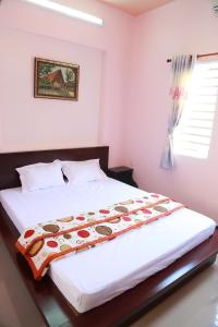 een slaapkamer met een groot wit bed in een kamer bij Ban Mai Hotel 66 in Phan Thiet