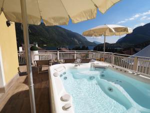 a hot tub on a balcony with an umbrella at Hotel Europa in Molveno