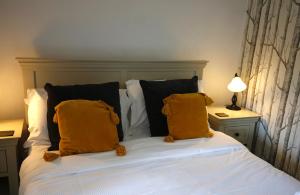 a bed with two yellow pillows on top of it at Ashfield House in Grassington