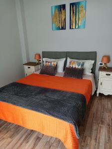 a bedroom with a large bed with an orange blanket at Decò & Retrò apartment in La Spezia