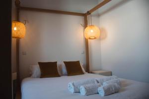 una camera da letto con un letto con due cuscini e due luci di Laurus - Charming House a Raposeira