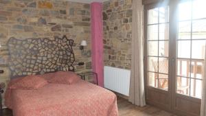 a bedroom with a bed and a stone wall at Hotel Rural La Casa del Peregrino in El Acebo de San Miguel +21 photos