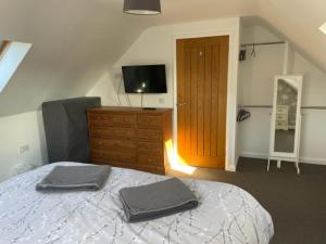 1 dormitorio con 1 cama, vestidor y TV en The Gatehouse, en Upwell