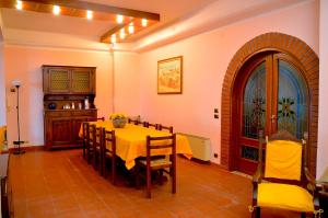 uma sala de jantar com uma mesa amarela e cadeiras em Angelo Delle Aci em Acitrezza