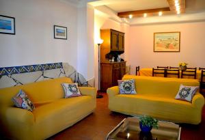a living room with two yellow couches and a table at Angelo Delle Aci in Acitrezza