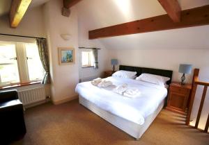 a bedroom with a large white bed with towels on it at Ashfield House in Grassington