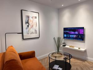 a living room with a couch and a tv at Apartament Na Krzywym Kole in Kazimierz Dolny