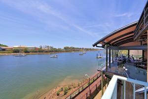 a building with a view of a river with boats at Burnett Riverside Hotel in Bundaberg