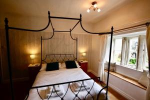 a bedroom with a black canopy bed and a window at Ashfield House in Grassington