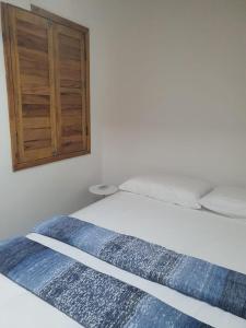 Cama en habitación con armario de madera en Nesga Village, en Lençóis