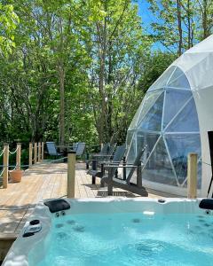 a hot tub with a igloo and chairs in a yard at Geodome water view stay on Grand Manan Island in Castalia