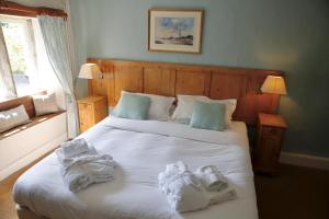 una camera da letto con un grande letto bianco con asciugamani di Ashfield House a Grassington