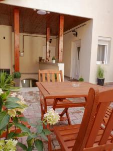 a patio with a wooden table and chairs at Várfal apartman in Eger