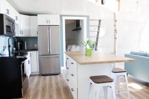 a kitchen with white cabinets and a kitchen island with stools at Geodome water view stay on Grand Manan Island in Castalia +4 photos