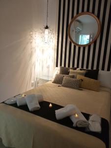 una camera da letto con un letto con asciugamani e uno specchio di El Sentir de Toledo parking incluido a Toledo