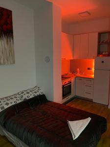 uma pequena cozinha com uma cama num quarto em Apartman Bulevard em Sarajevo