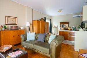 uma sala de estar com um sofá e uma cozinha em Magnificent Loft Athens Voula em Atenas