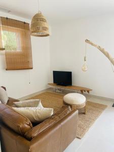 sala de estar con sofá marrón y mesa en Villa Gebano, en Saussines